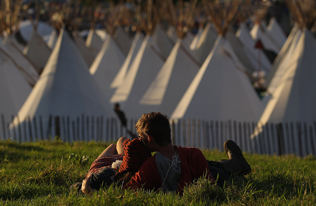 These lovebirds watched the sunset together on the grass at the Glastonbury festival.
