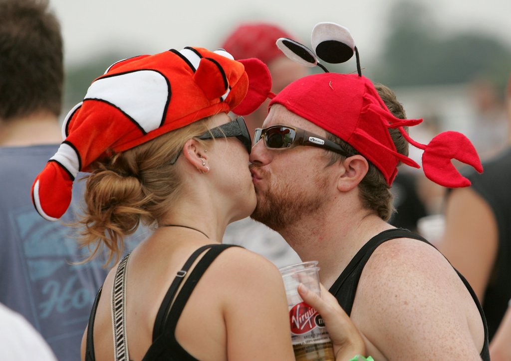 A couple kissed in fish hats at the Virgin Festival in Baltimore, MD.  
