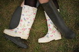 A couple in rainboots laid in the grass at the Big Chill festival near Ledbury in Herefordshire, England.
