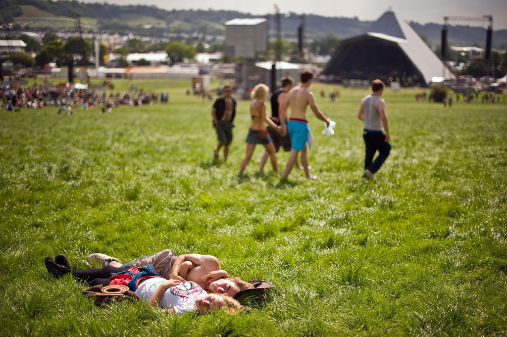 A couple soaked up the sun in the grass at the annual Glastonbury festival in England.
