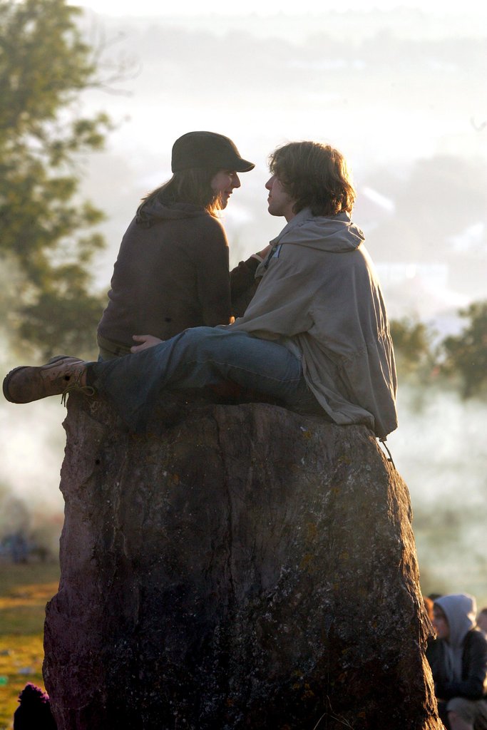 Lovebirds sat at the stone circle at Glastonbury festival in England.
