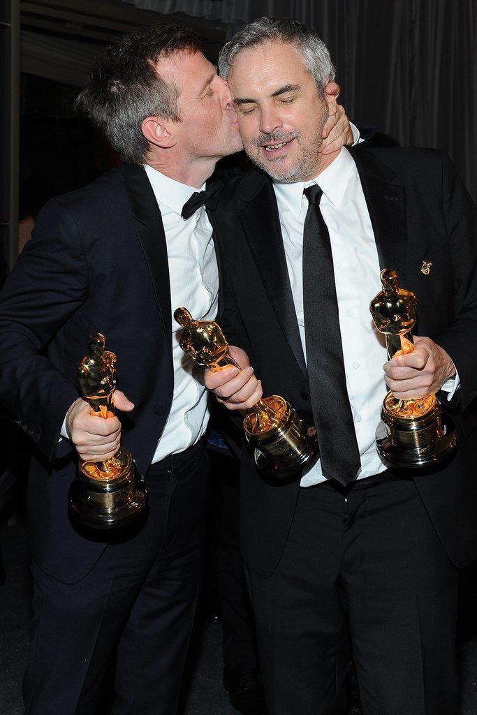 Spike Jonze, who won the Oscar for best original screenplay for Her, planted one on best director winner for Gravity Alfonso Cuarón.
