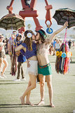 A Coachella couple kissed while holding umbrellas.
