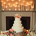 This is the perfect example of how you can take a plain tiered cake and turn it into a dessert with flair. Here, the extra details — the stand, the candles, the flowers — make it stand out, but it could just as easily look great without them. 
Photo by Kristyn Hogan via Wedding Chicks
